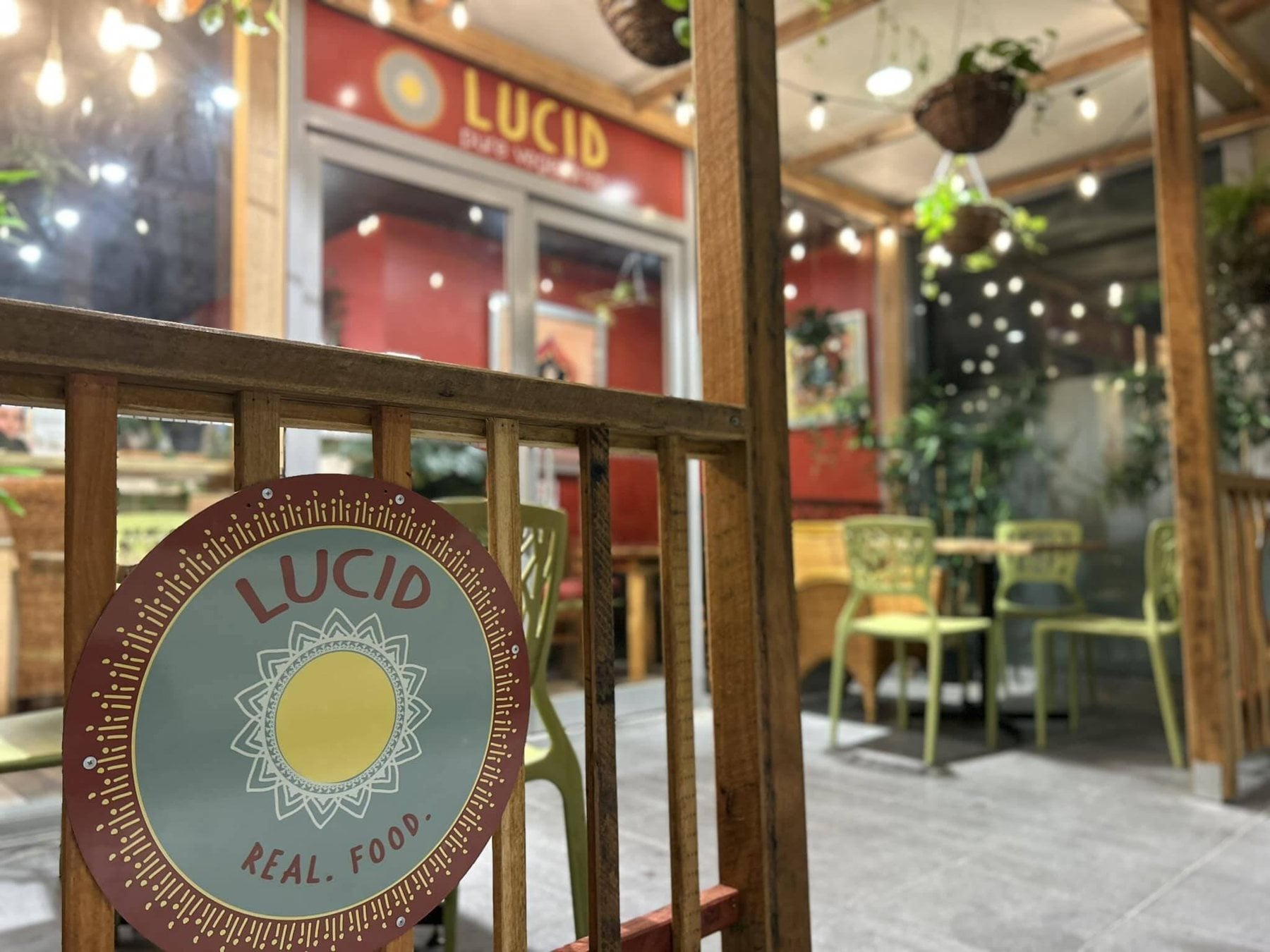 The Lucid Pure Vegetarian shopfront at Sunnyside Mall, with its round sun sign and green chairs
